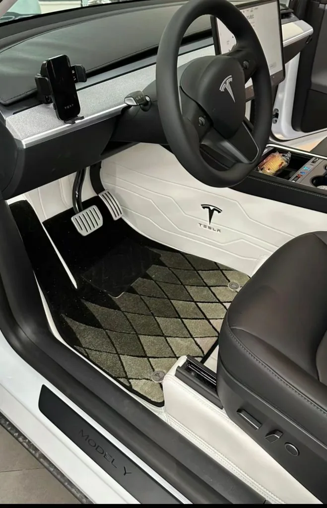 Custom black and white car floor mats in a Tesla Model Y